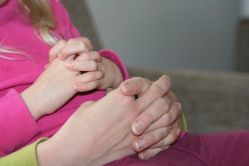 Rukoilevat äidin ja tyttären kädet